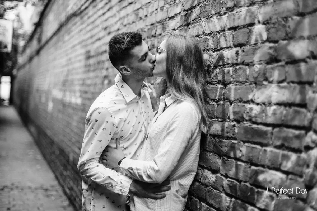 Couple enlace contre un mur de briques dans le vieux Lille
