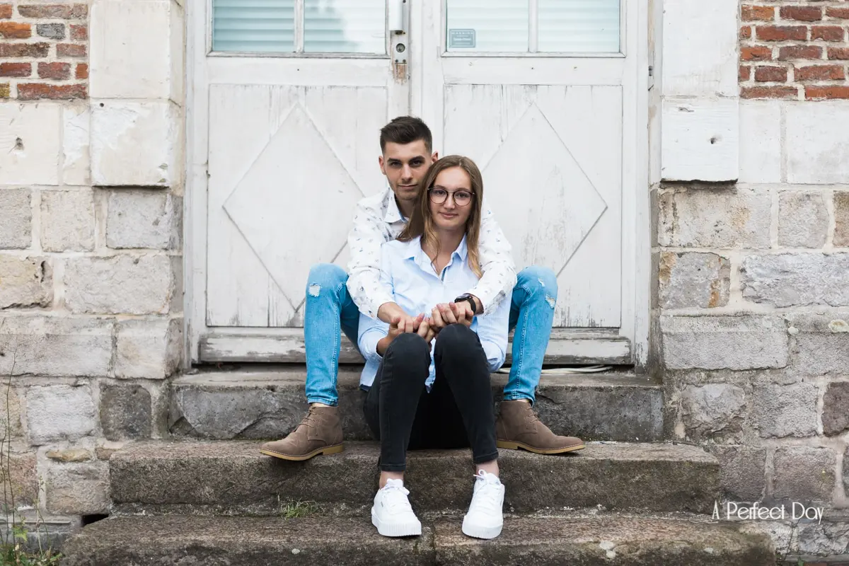 Couple assis sur les marches devant une porte ancienne du vieux Lille