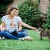 Famille heureuse jouant avec un chat en jardin.