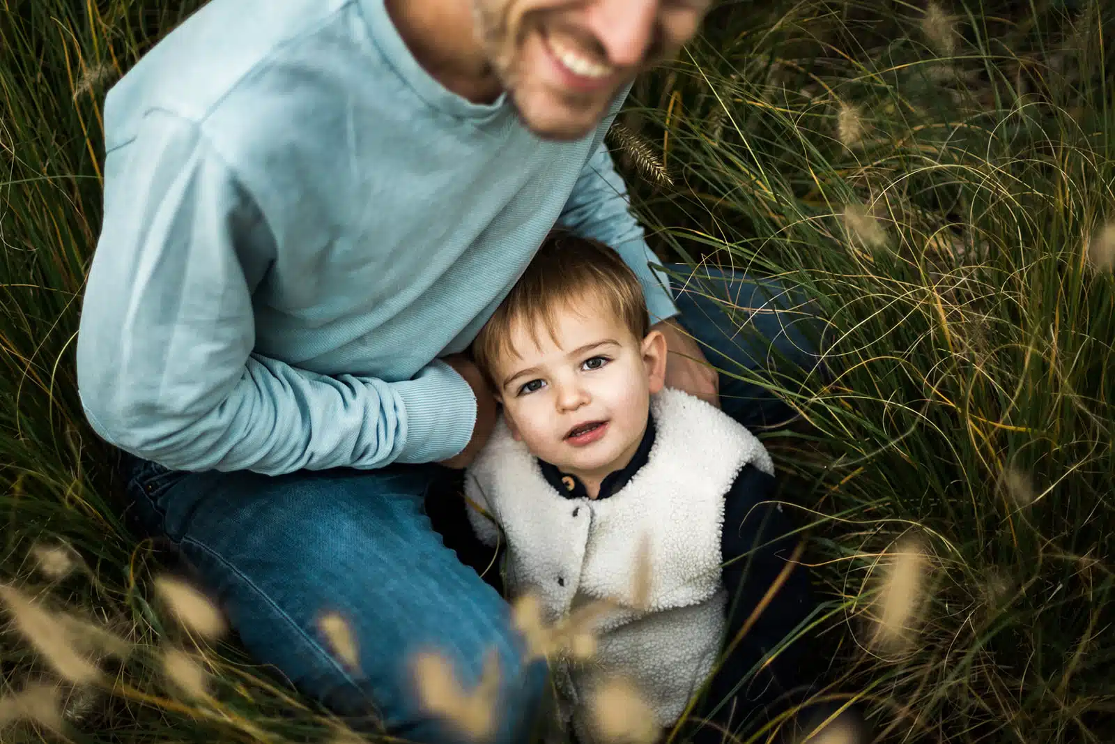 Papa et son fils dans les herbes hautes pendant une seance photo famille