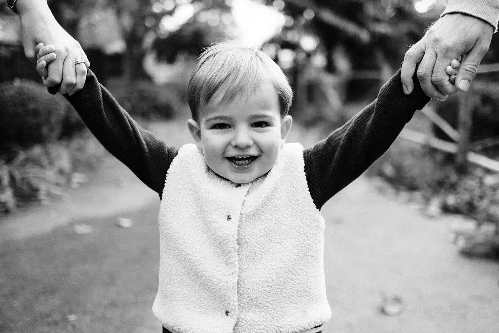 Enfant souriant tenu par la main au jardin des geants a Lille