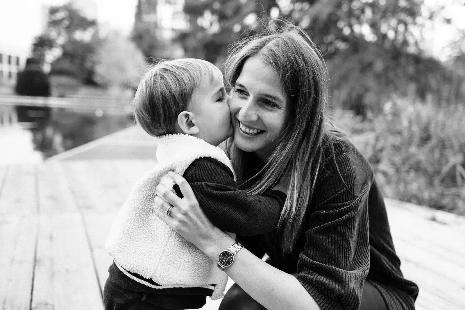 Petit garcon embrassant sa maman au bord du bassin du jardin des geants