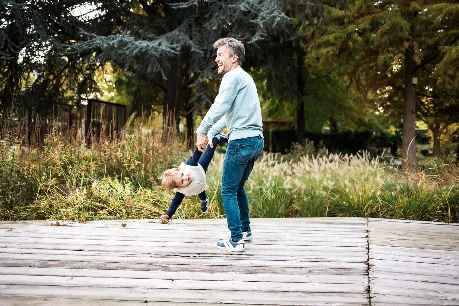 Maman jouant avec son enfant sur une passerelle en bois a Lille