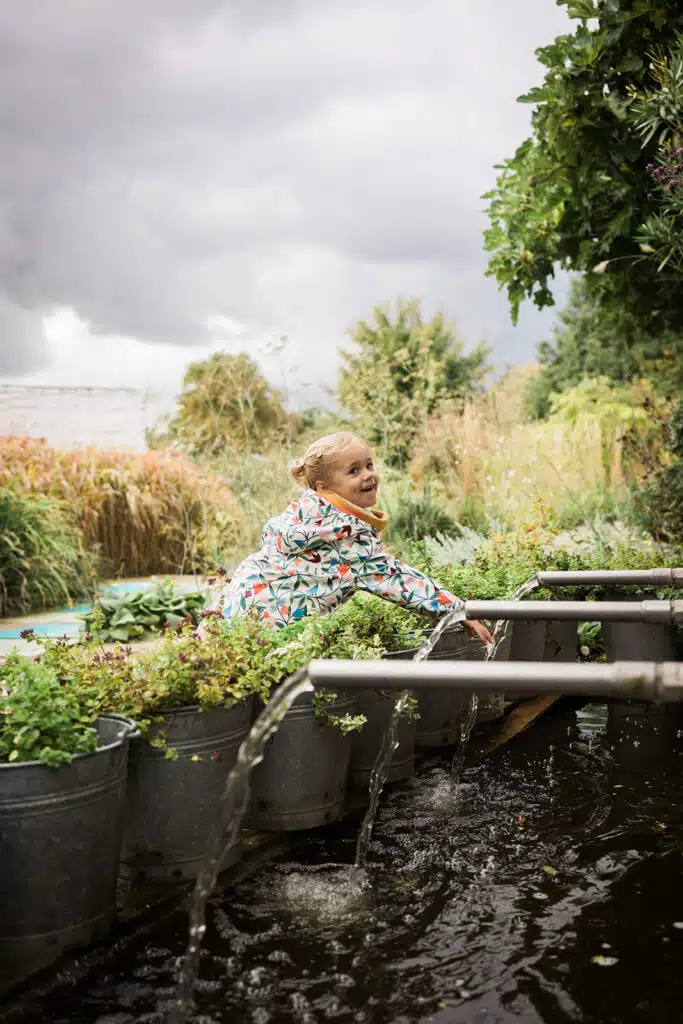 Enfant jouant joyeusement dans un jardin aquatique