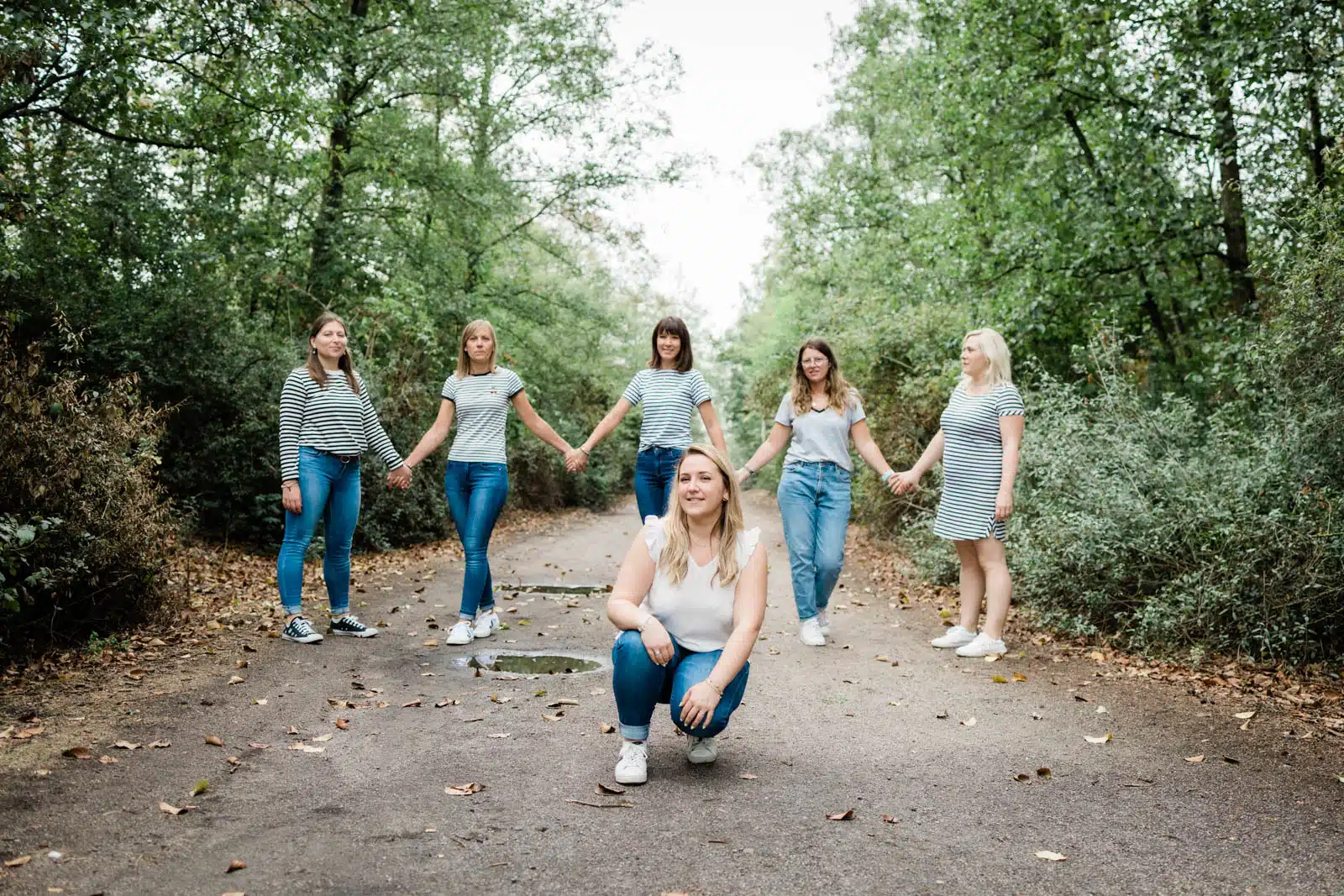 Groupe de femmes se tenant la main en forêt