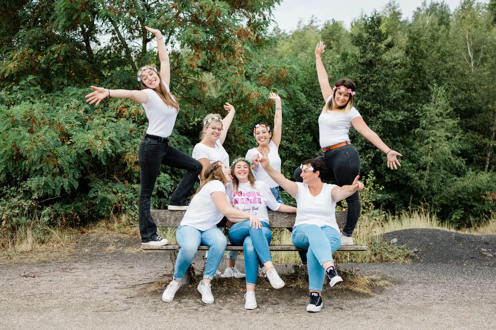 Amies en pose rigolote sur un banc dans un parc, séance photo EVJF