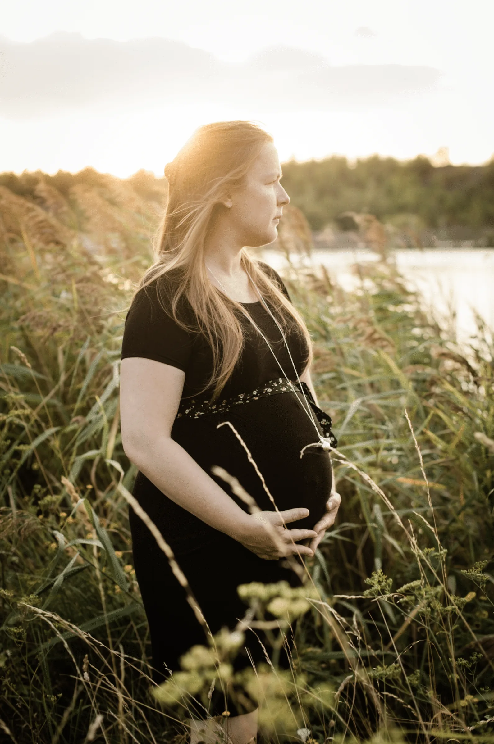 Femme enceinte au coucher du soleil dans la nature.
