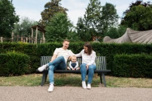 Famille heureuse assise sur un banc en parc.