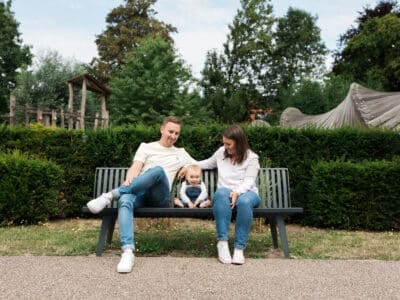 Famille heureuse assise sur un banc en parc.