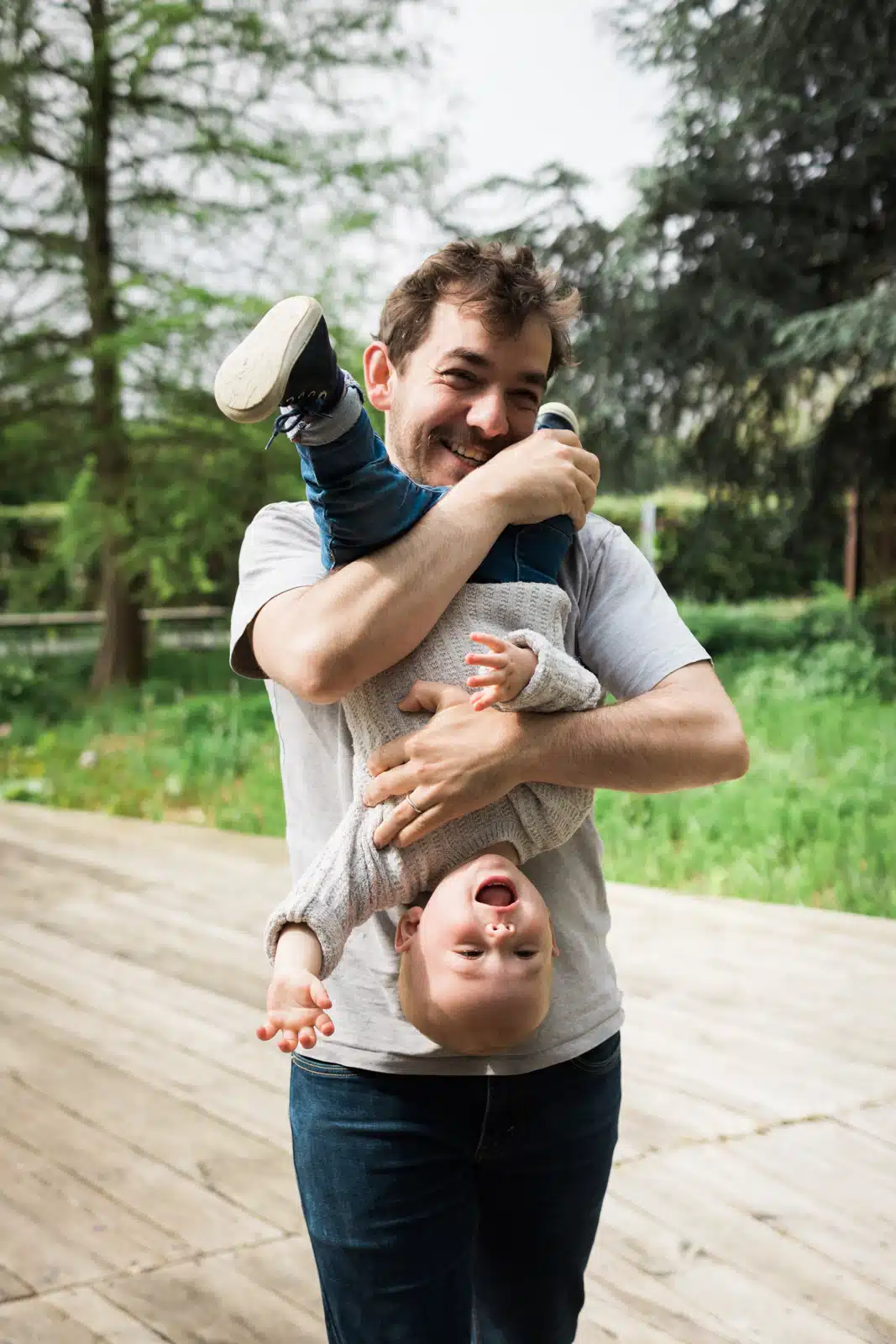 Père jouant avec son enfant en plein air.