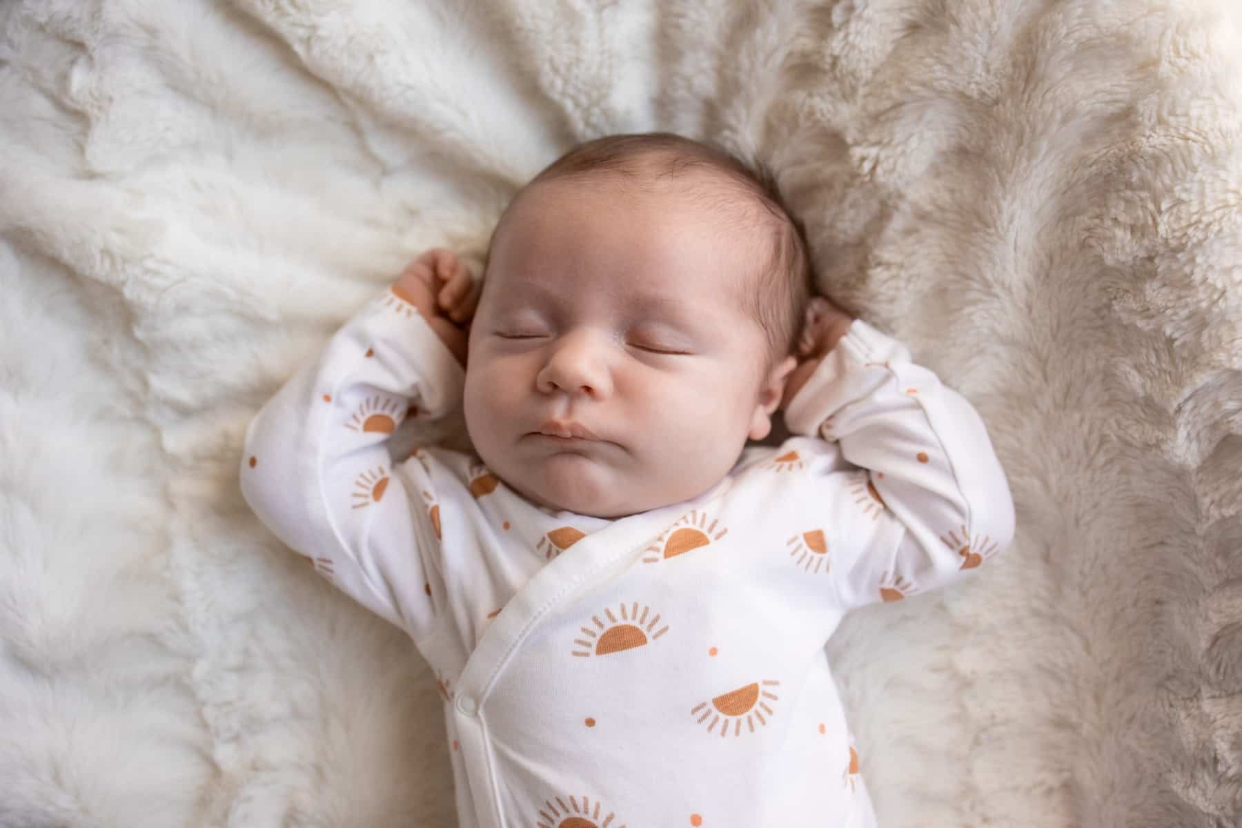 Nourrisson dormant paisiblement sur fond douillet.