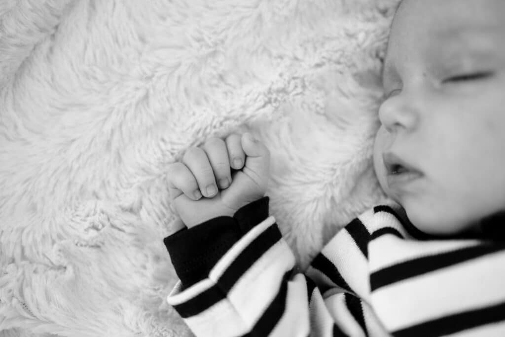 Bébé dormant paisiblement en noir et blanc.