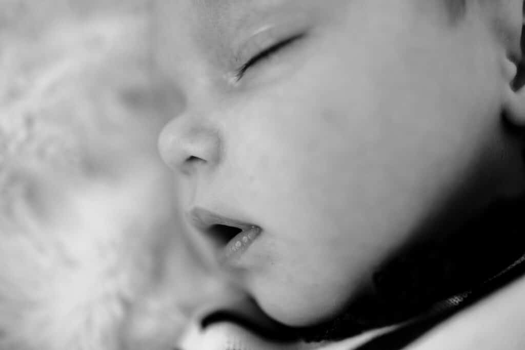 Bébé endormi en gros plan, photo noir et blanc.