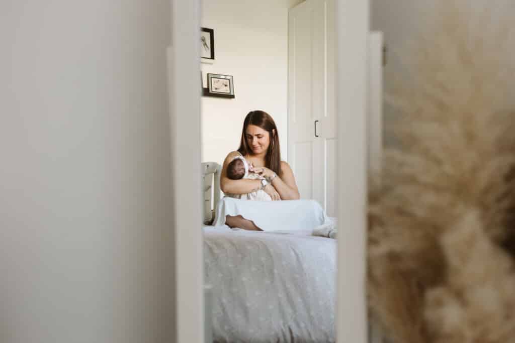 Mère allaitant bébé dans chambre lumineuse.