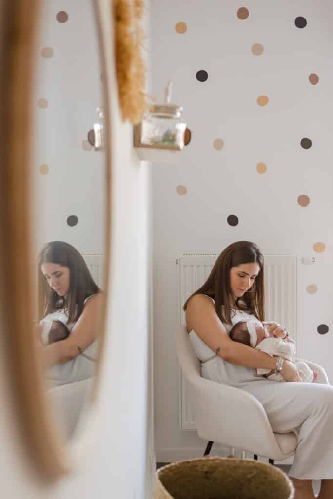 Mère berçant bébé, chambre enfant, reflet miroir.