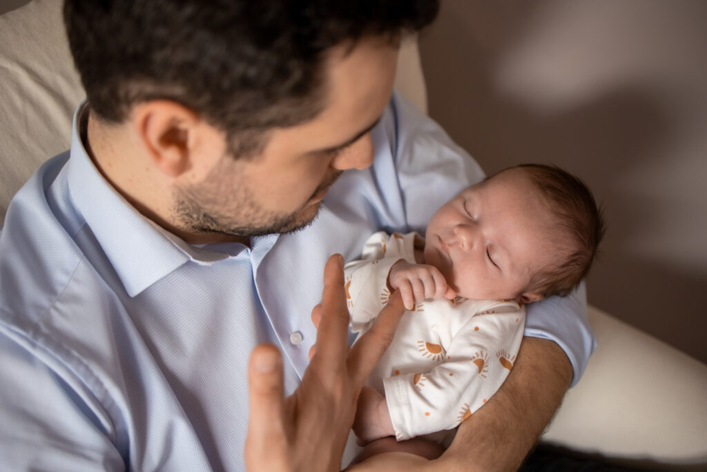 Père tenant doucement son nouveau-né endormi