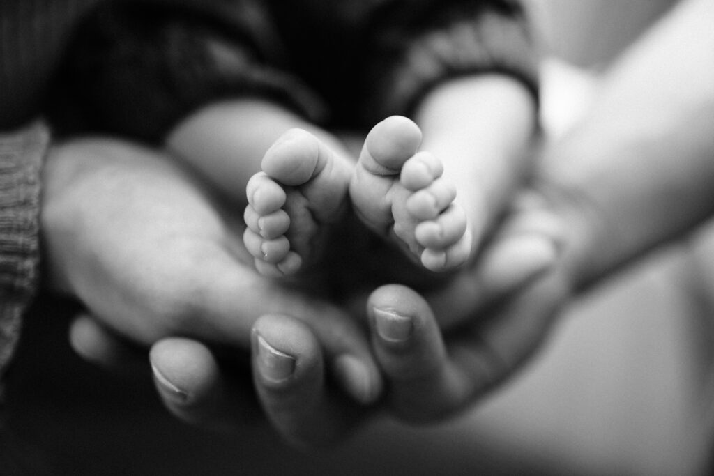 Mains tenant petits pieds bébé.