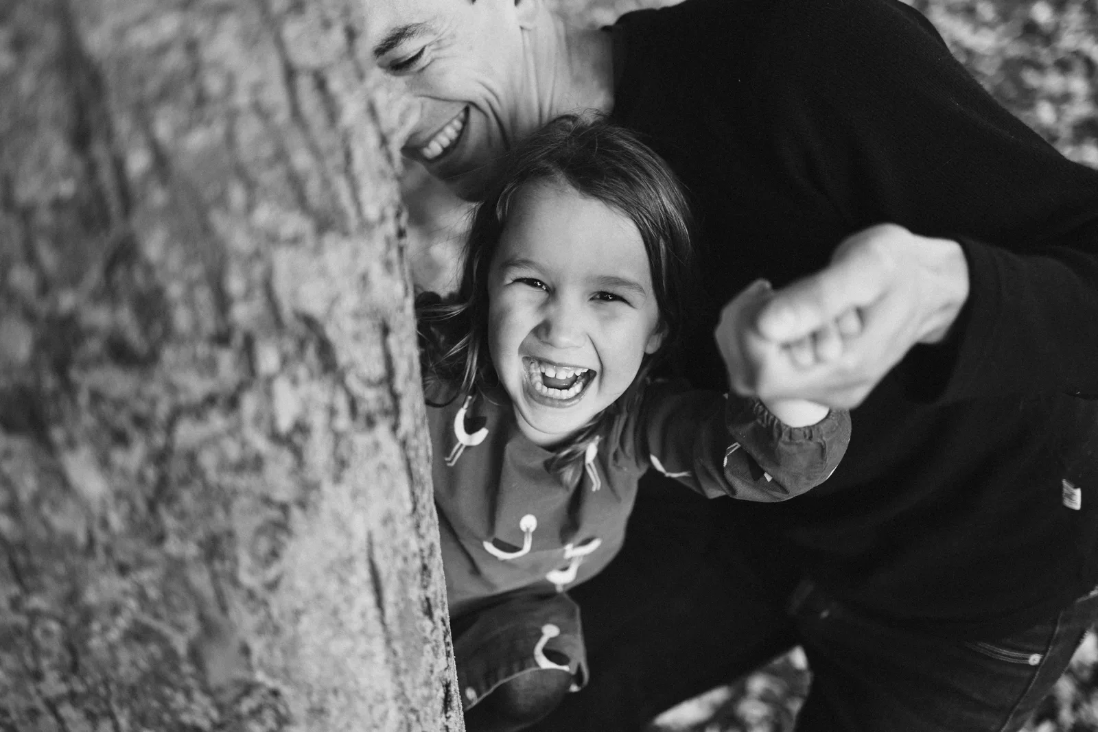 Papa riant avec sa fille contre un arbre photo noir et blanc