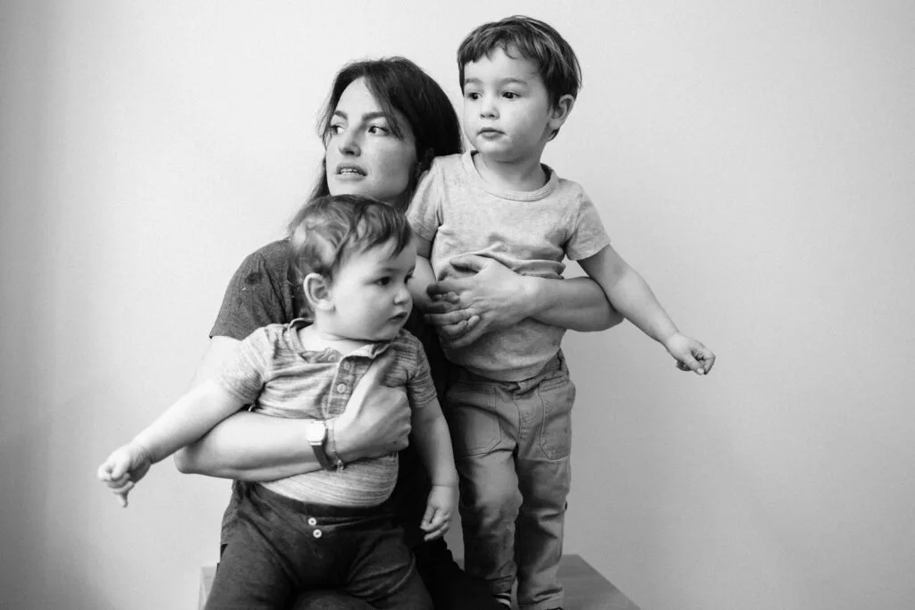 Mère avec deux jeunes enfants en noir et blanc.