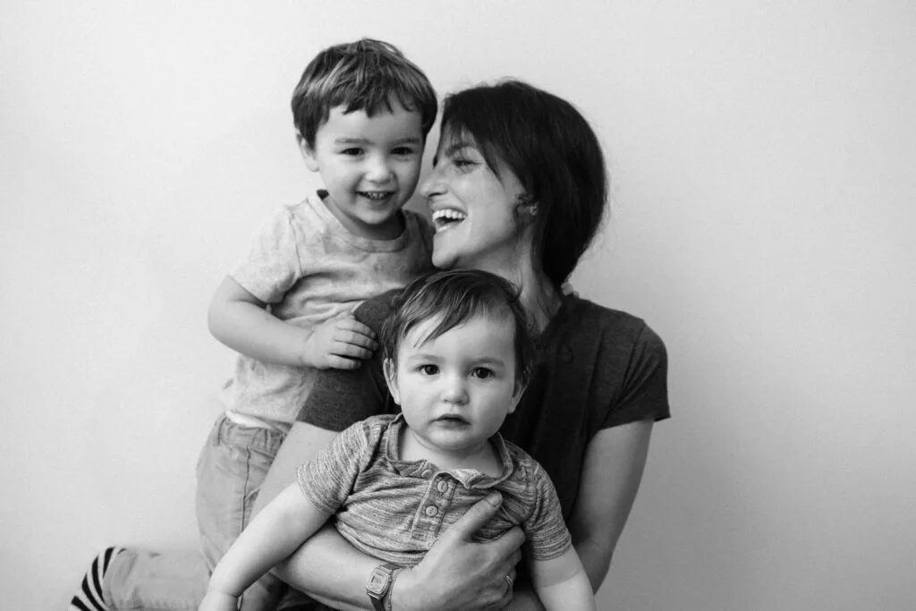 Mère souriante avec deux jeunes enfants.