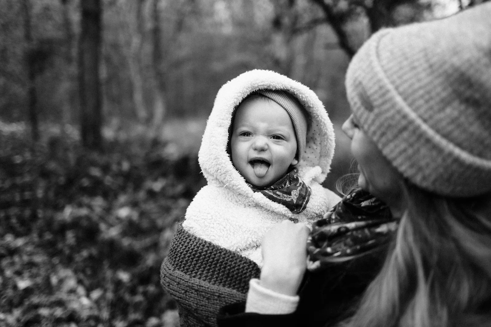 Maman riant avec son bebe en combinaison hiver photo noir et blanc