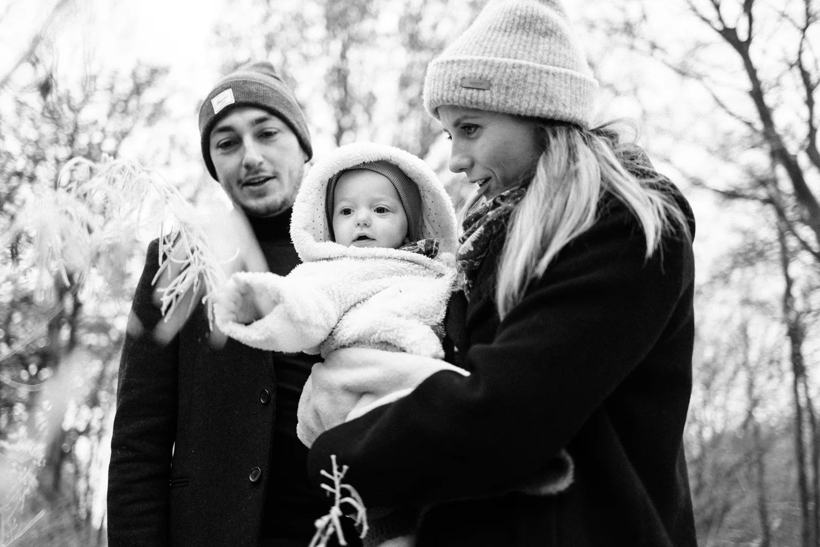 Parents en bonnet tenant leur bebe pendant une seance photo hiver a Lille