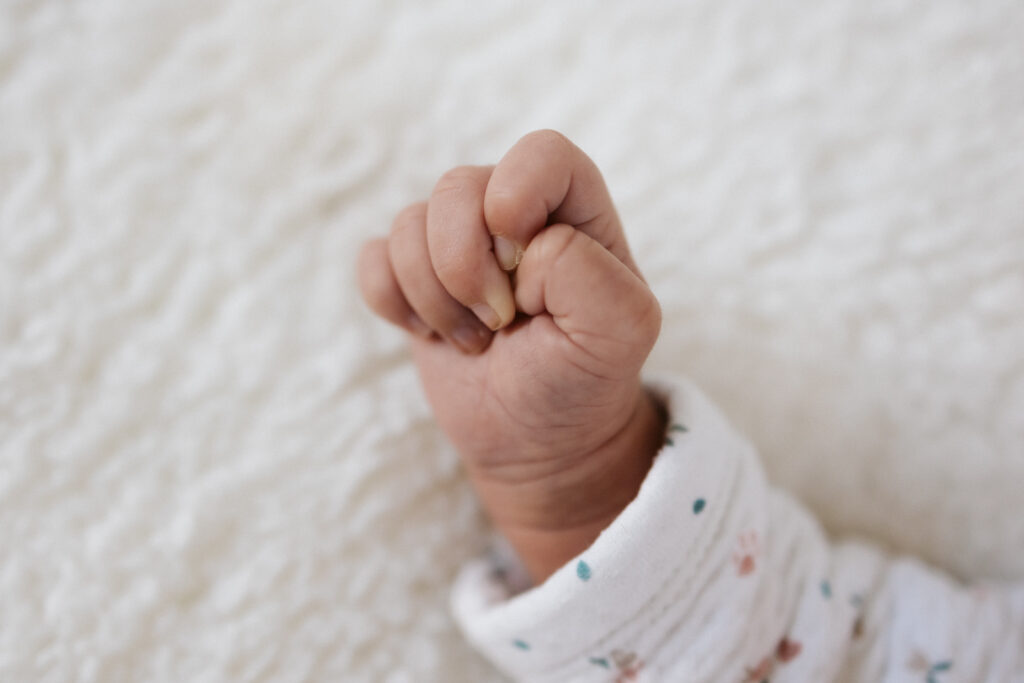 Main de bébé Rosalie en gros plan, immortalisés par un photographe professionnel spécialisé en naissance à Arras.