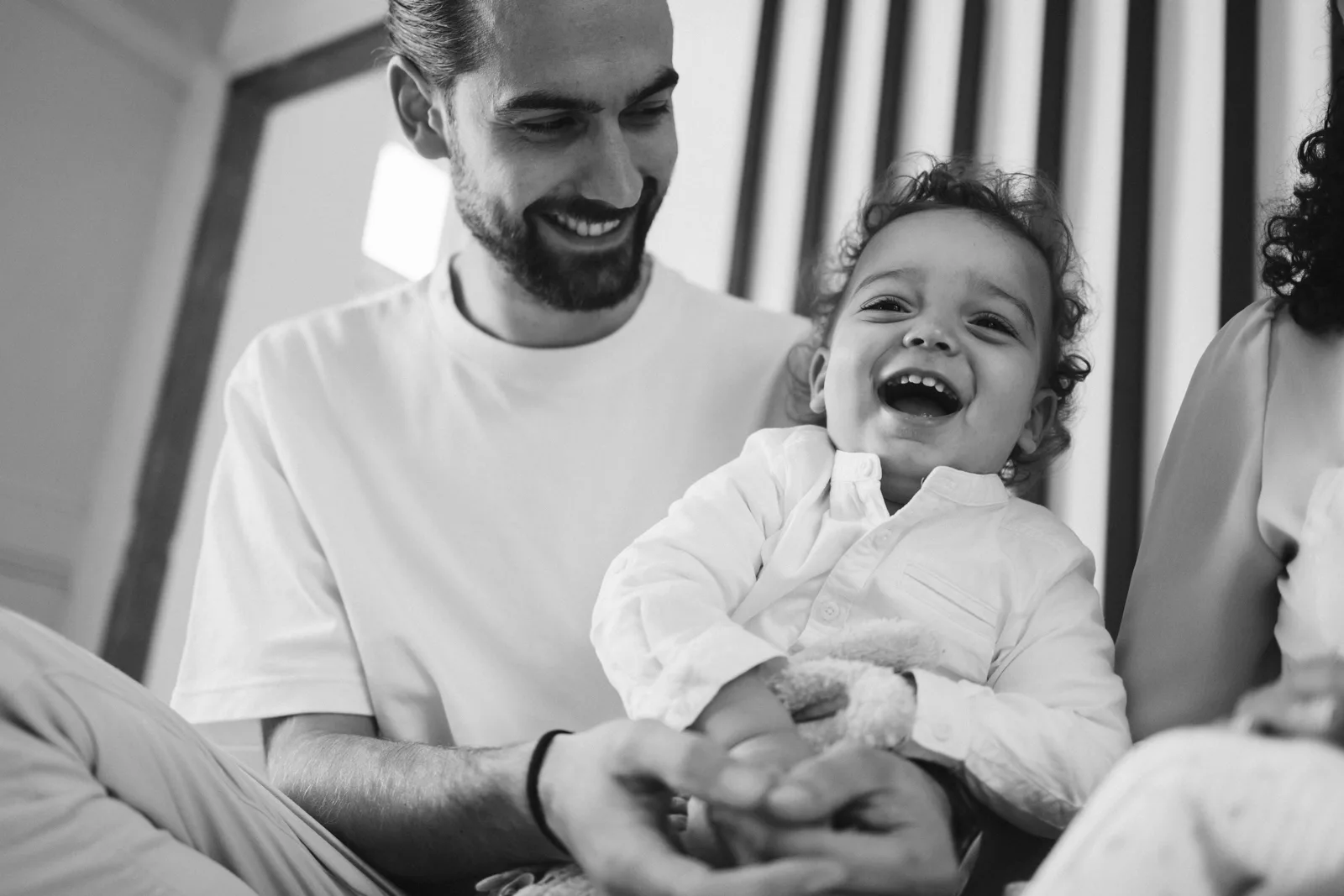 Papa riant avec son fils pendant la seance photo naissance a domicile