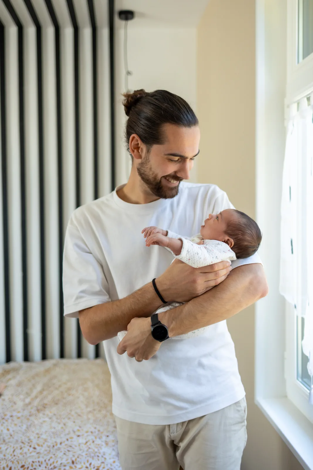 Papa bercant son nouveau-ne pres de la fenetre a Arras