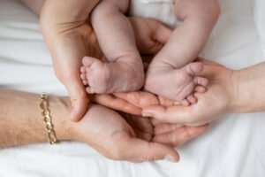 Mains d'adultes tenant pieds de bébé