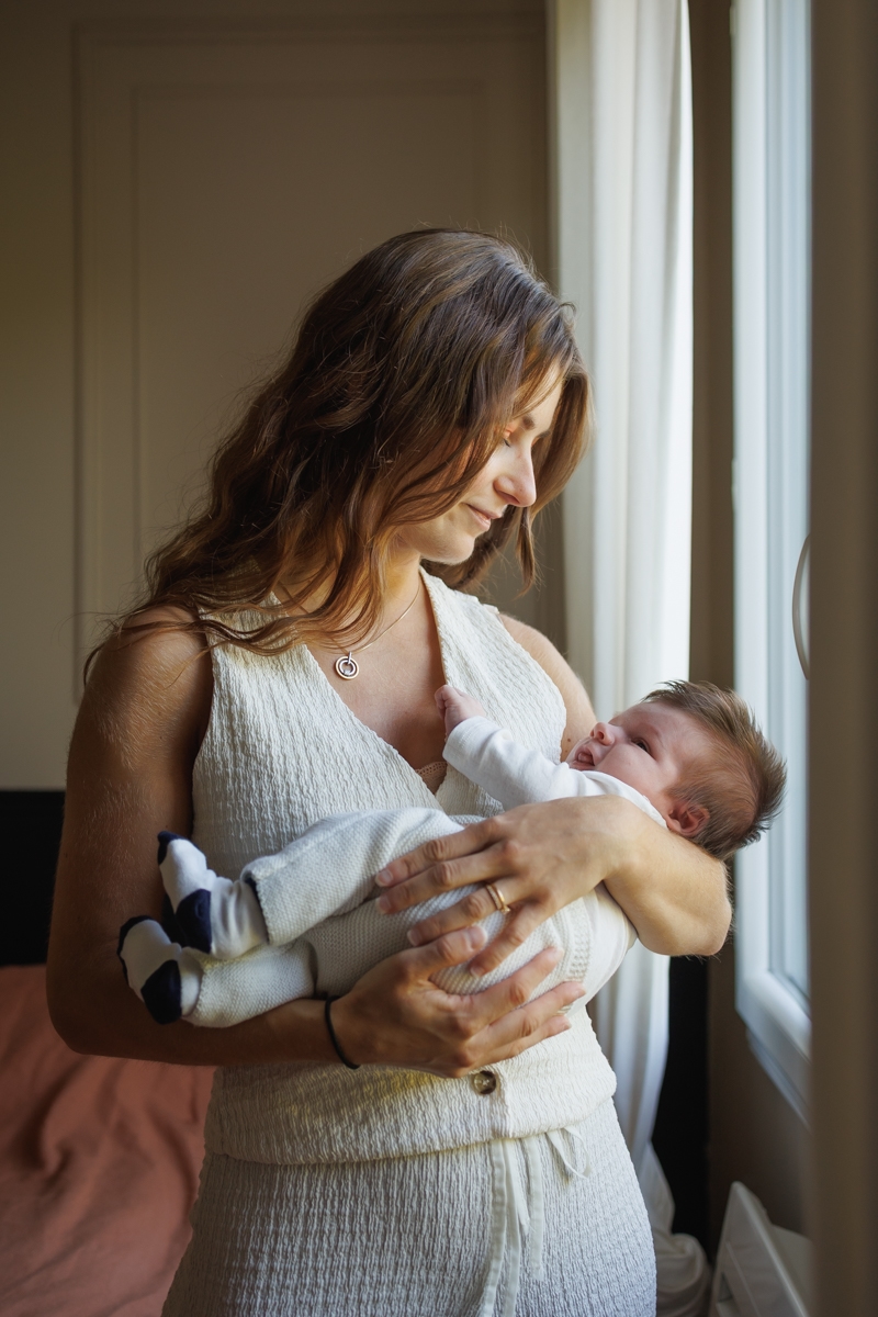 Maman tenant son nouveau-ne contre elle avec tendresse lors d une seance photo naissance