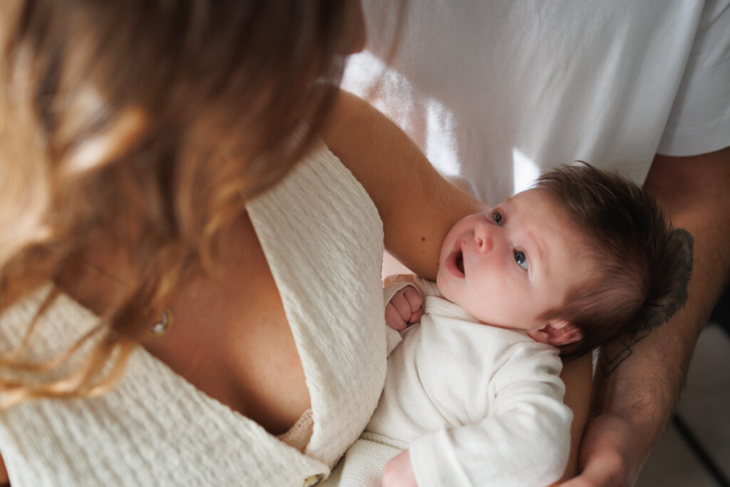 Maman avec son bébé dans les bras pendant une séance photo naissance