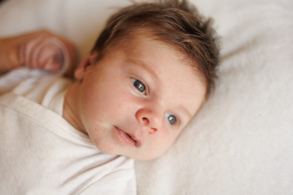 Bebe eveille sur un lit blanc lumiere naturelle et douceur