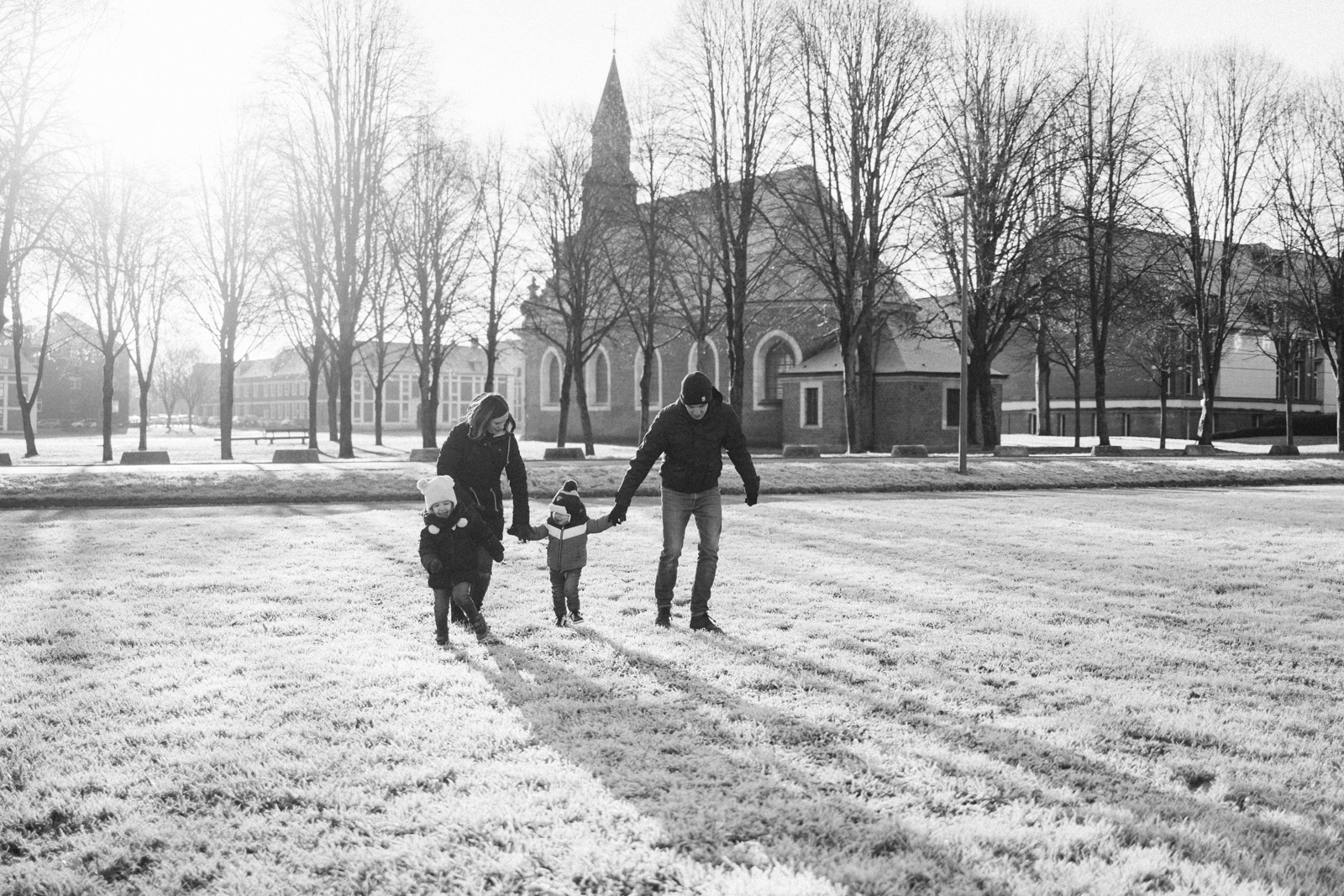Famille marchant dans la neige en noir et blanc - photographe famille citadelle Arras