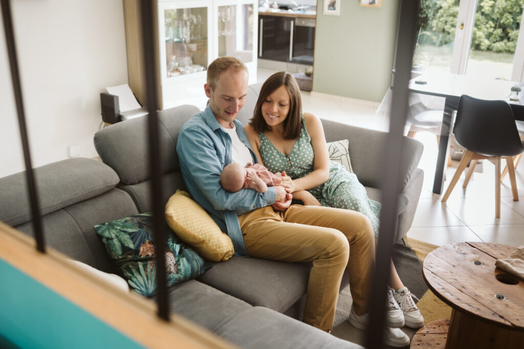 Parents et nouveau-ne sur canape, photographe naissance Arras