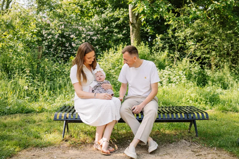 Famille assise sur un banc avec leur bebe au parc du Heron pres de Lille